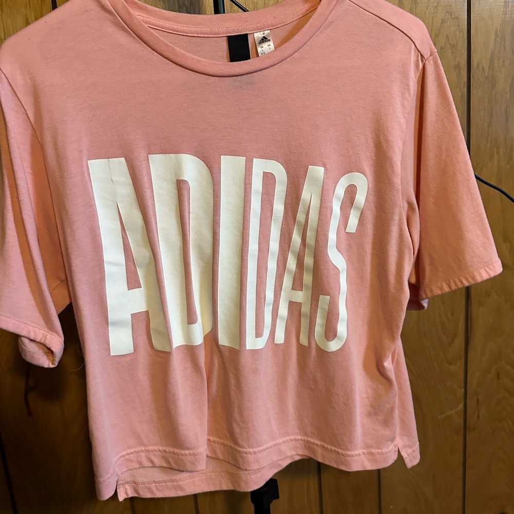 Pink shirt with “Adidas” in large white font
